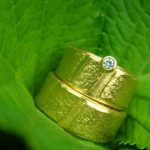 ARS Trauringe - strukturiert, Gelbgold mit Brillant bei Juwelier Solitaire Freiburg